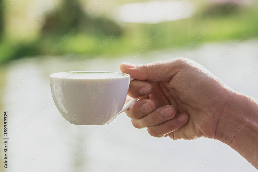 white cup of hot drink in a hand