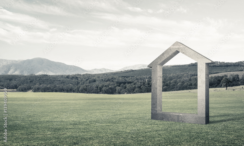 Conceptual background image of concrete home sign on green grass