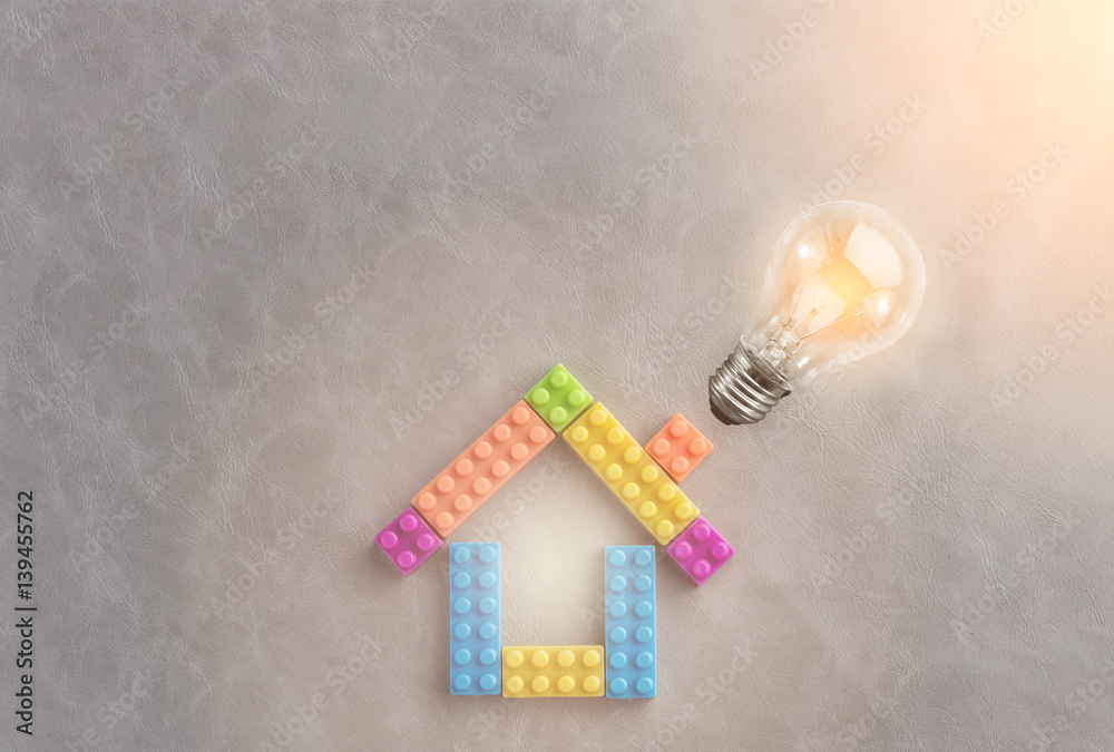 House concept with plastic blocks toy with glowing light bulb and free copyspace