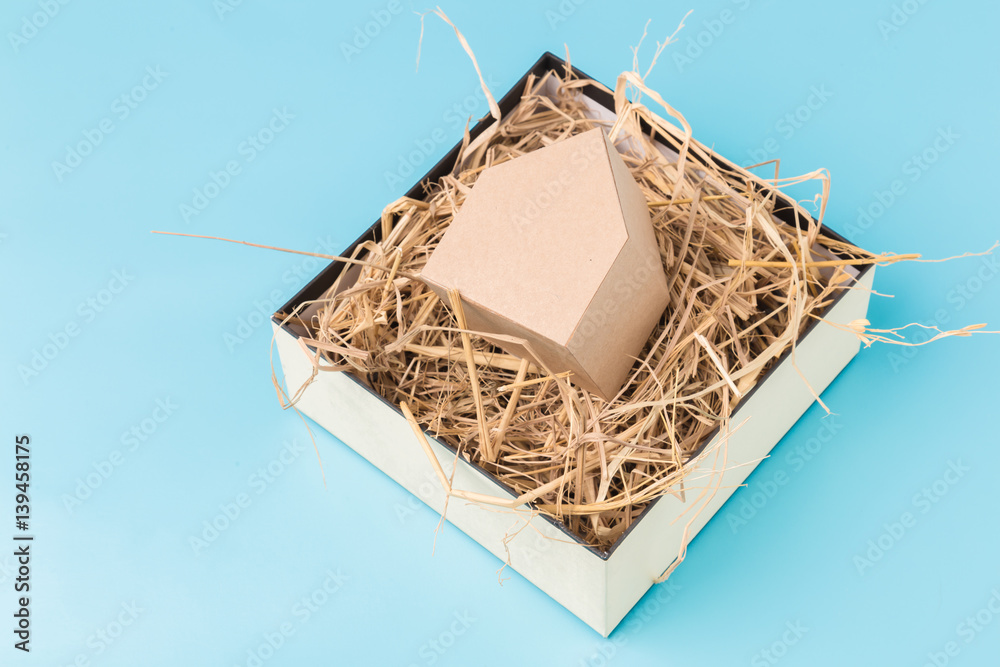 house model cardboard in a box with hay and free copyspace house concept