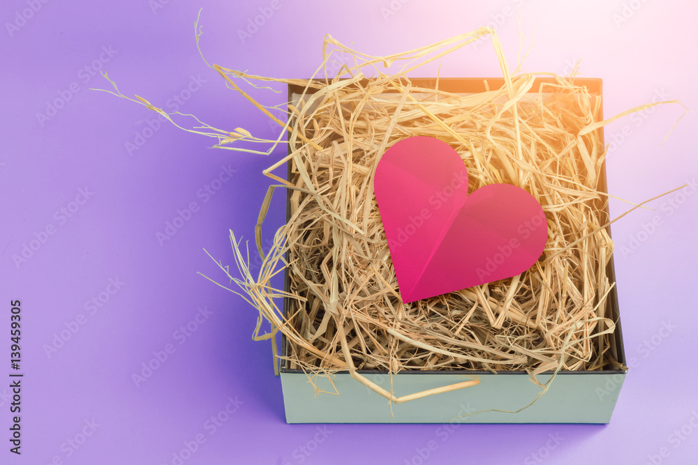 red heart paper shape on dry grass texture background with free copyspace love concept