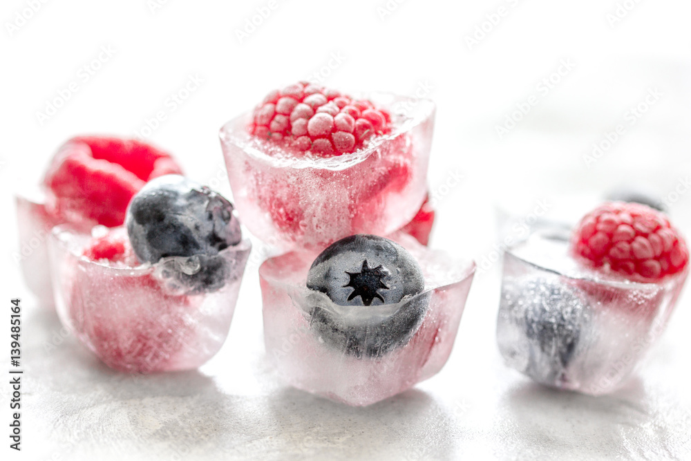 fresh blueberry and raspberry in ice on table background