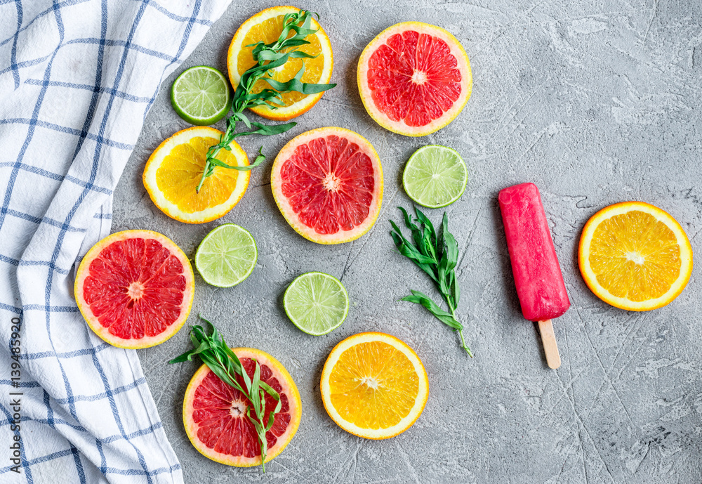 citrus popsicles with fruit slices on stone background top view