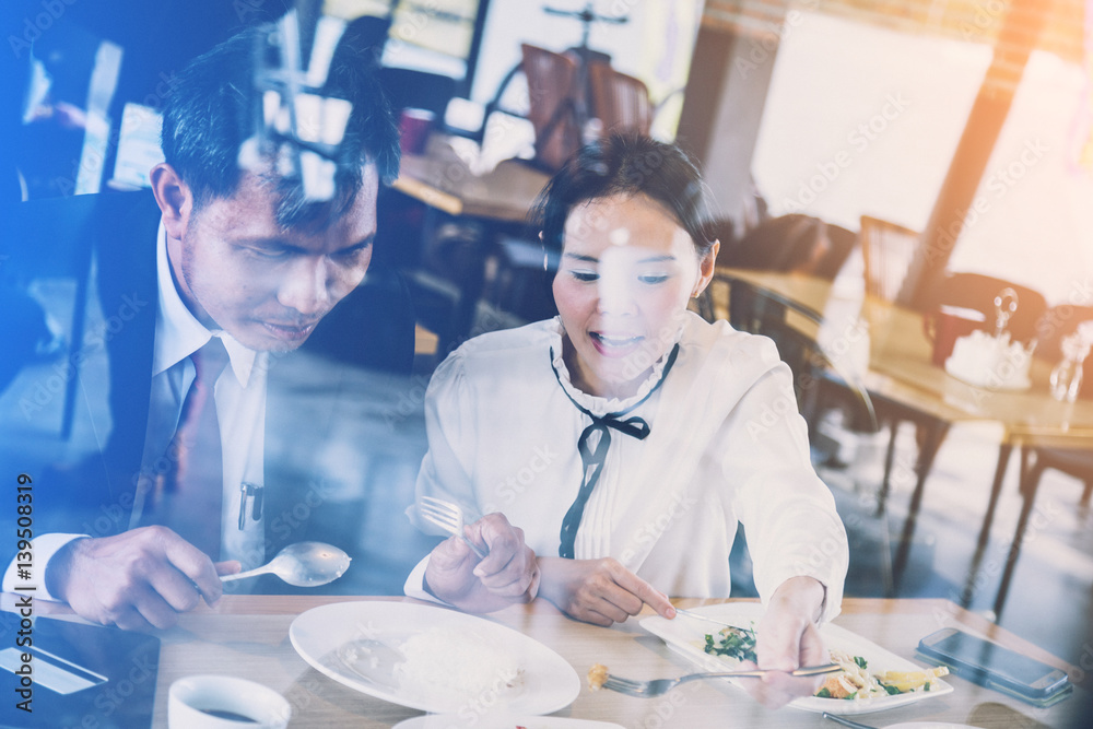 asian couple eating and laugh at restaurant view from outside window shop