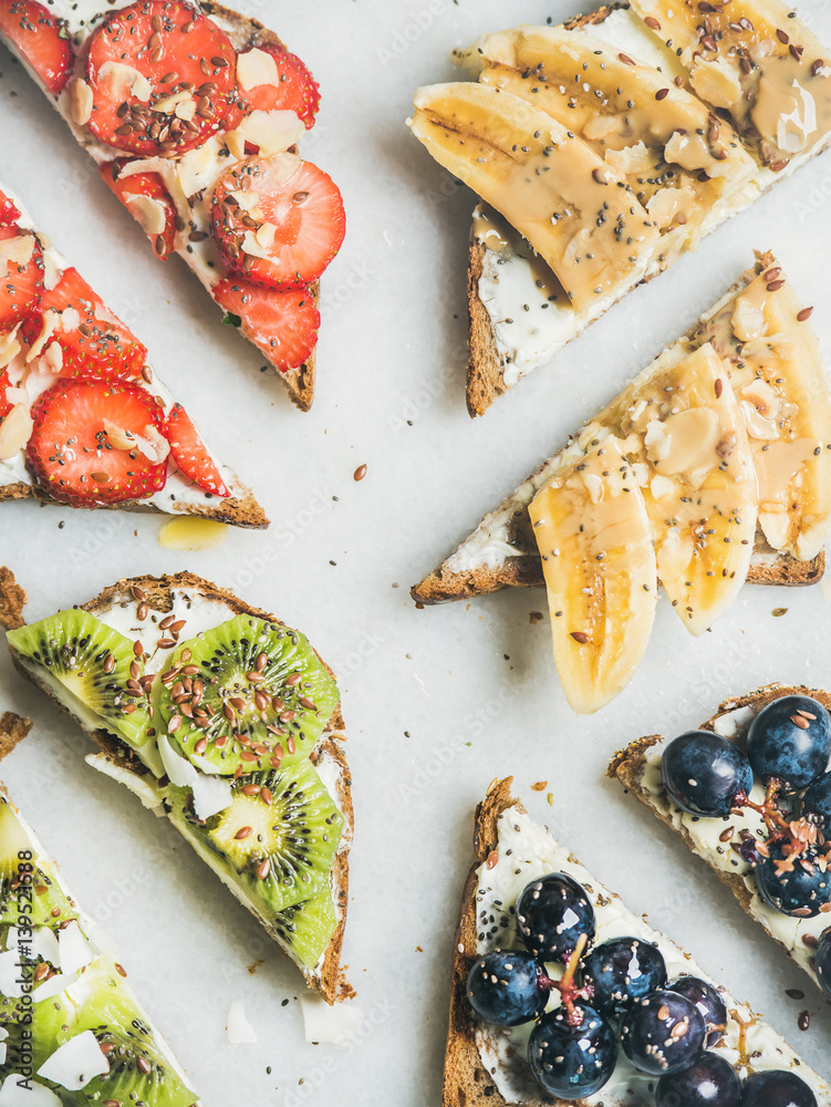 Healthy breakfast toasts cut in pieces. Wholegrain bread slices with cream cheese, various fruit, se