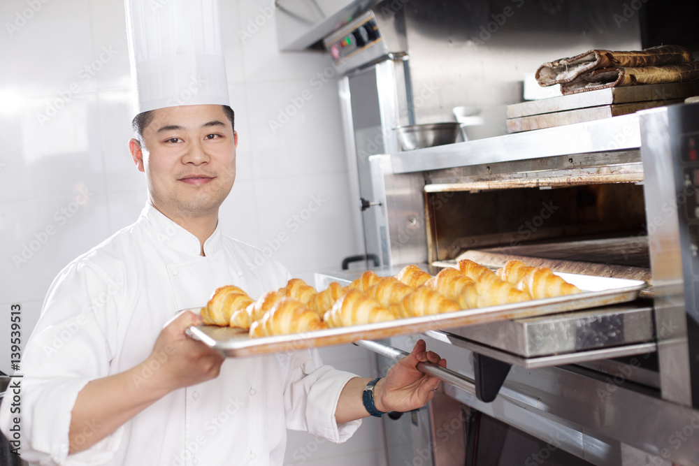 young man chelf makes bread in kitchen