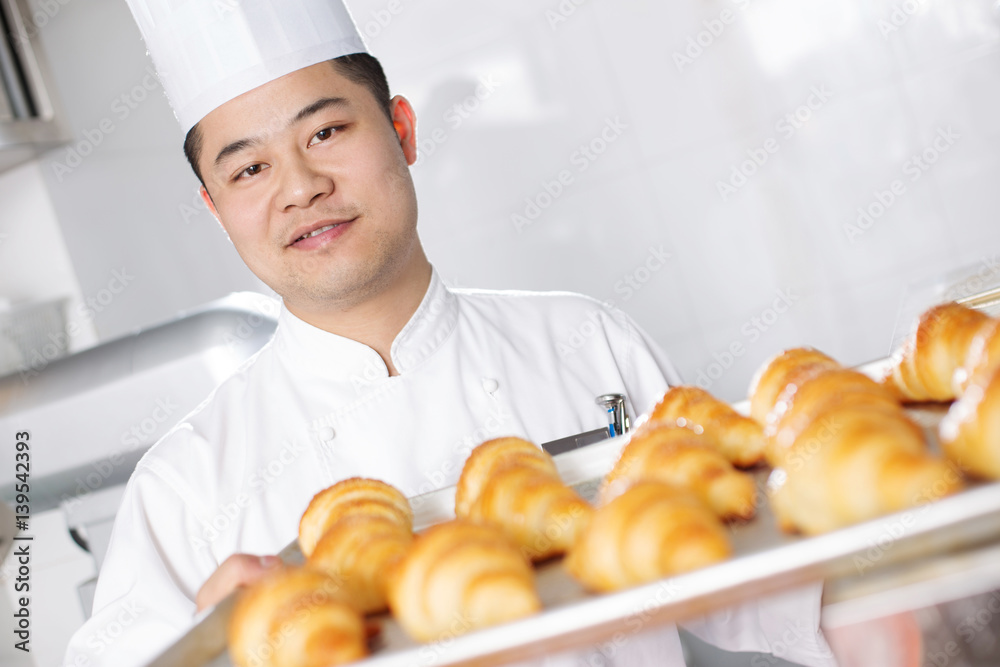 young man chelf makes bread in kitchen