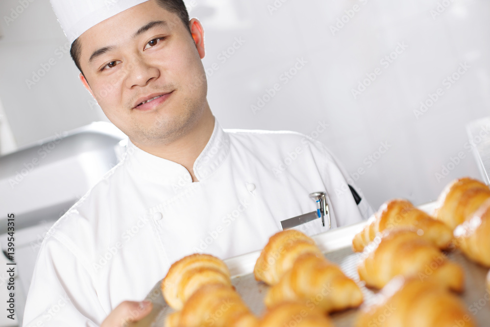 young man chelf makes bread in kitchen