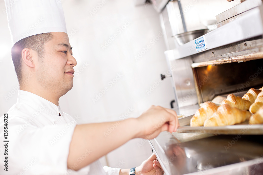 young man chelf makes bread in kitchen