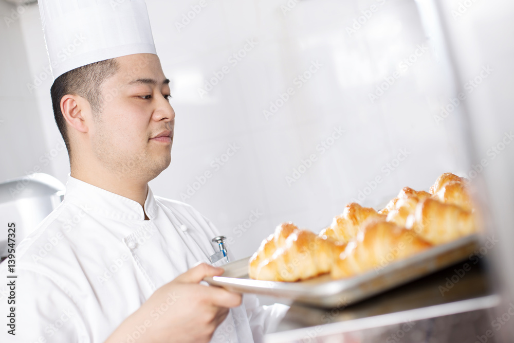 young man chelf makes bread in kitchen