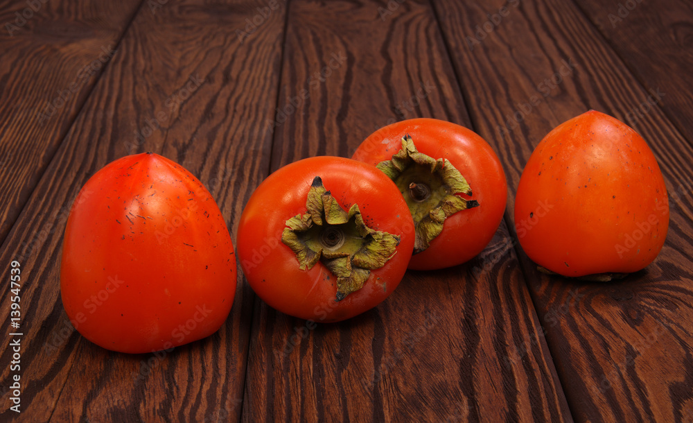  persimmon fruit on wooden background