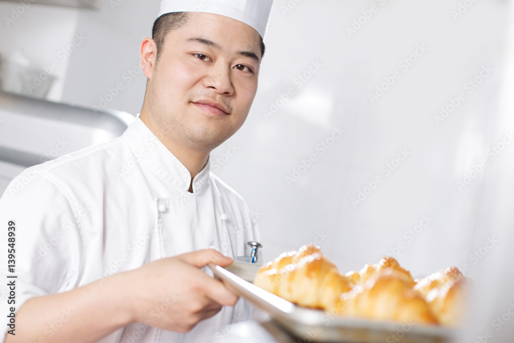 young man chelf makes bread in kitchen