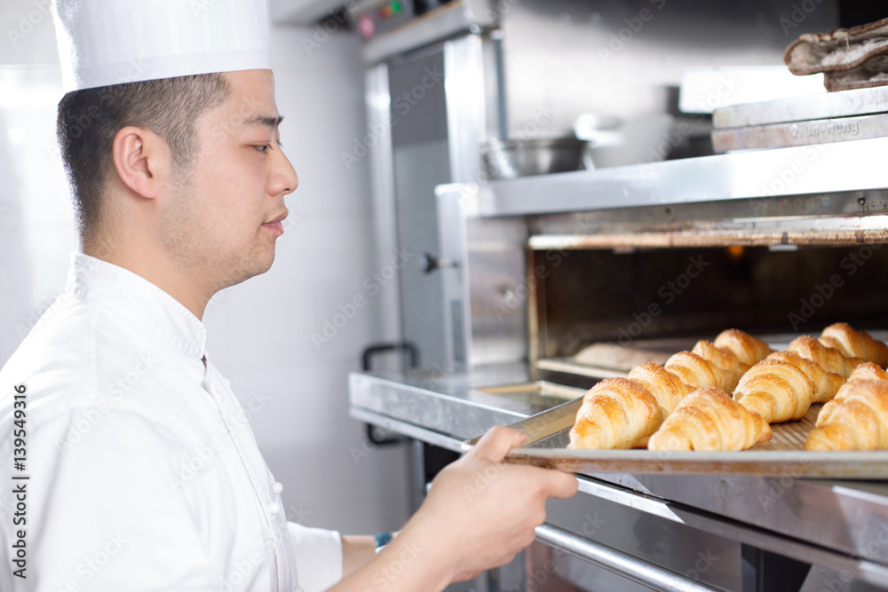 young man chelf makes bread in kitchen