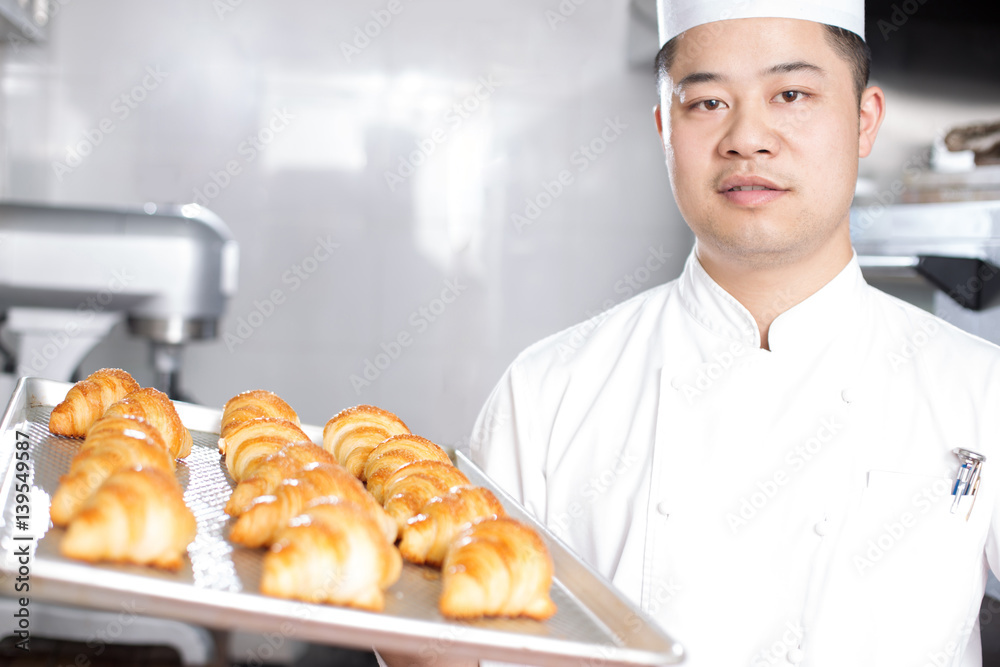 young man chelf makes bread in kitchen