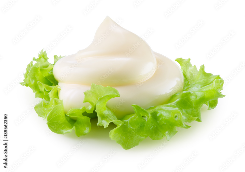 Handful of mayonnaise isolated on white background. Swirl on green salad leaf. With clipping path.