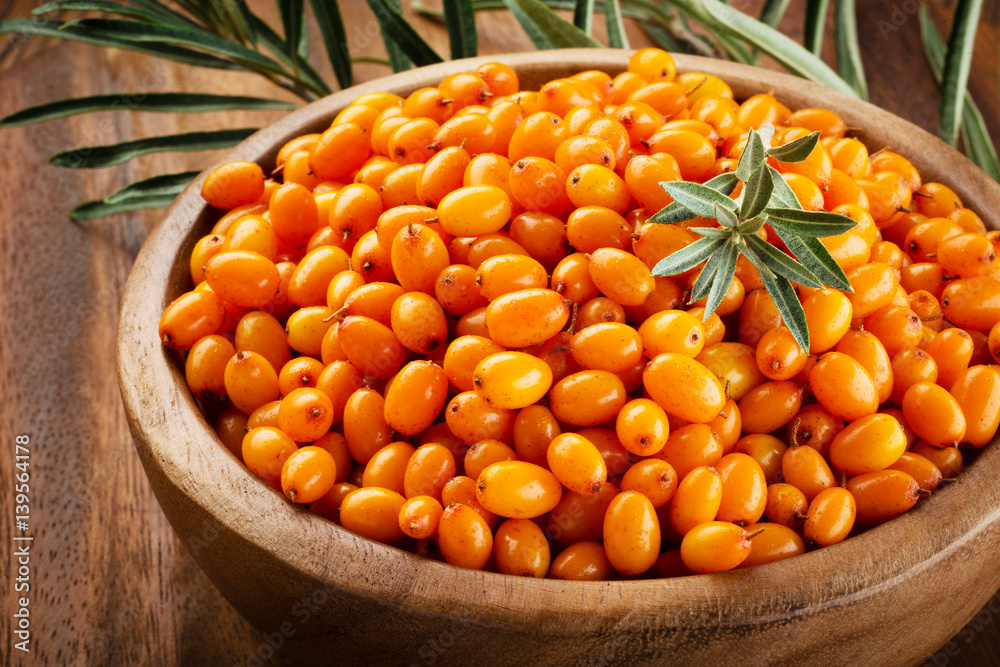 Sea buckthorn. Fresh ripe organic berries on wooden background.