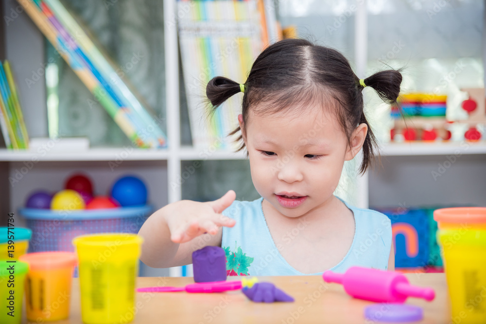 Little asian girl playing dough at school