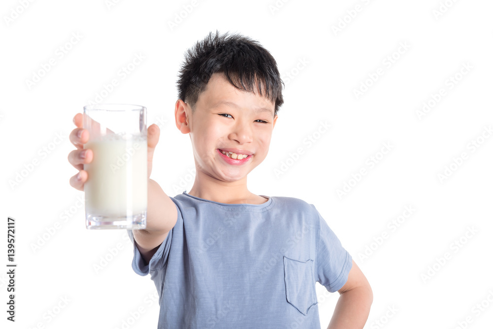 Young asian boy holding a glass of milk over white background