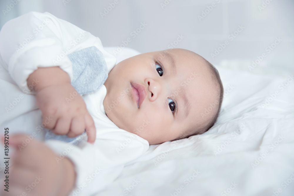 Little asian child lying on bed and looking something