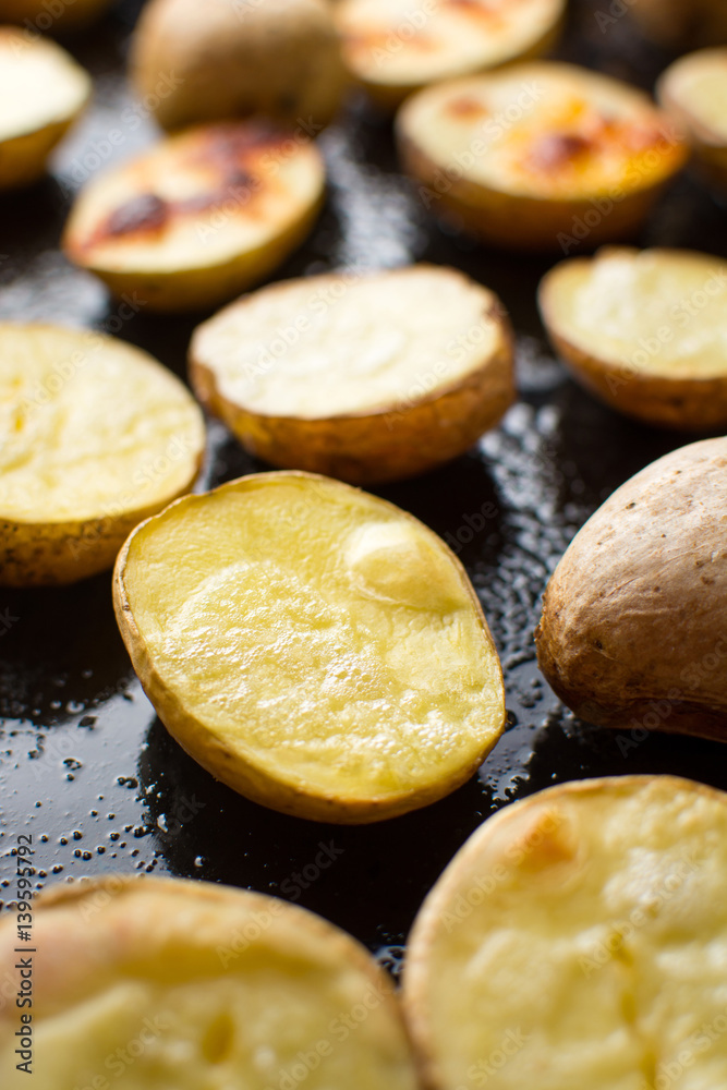 Roasted potato on a black baking plate