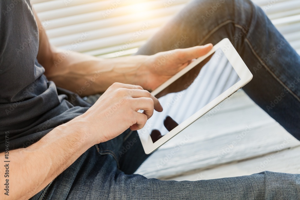 Man works on digital tablet.