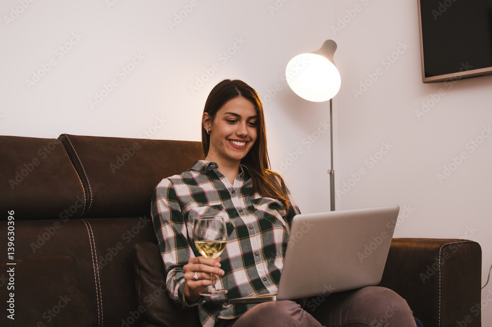 Gril drinking wine and surfing the web