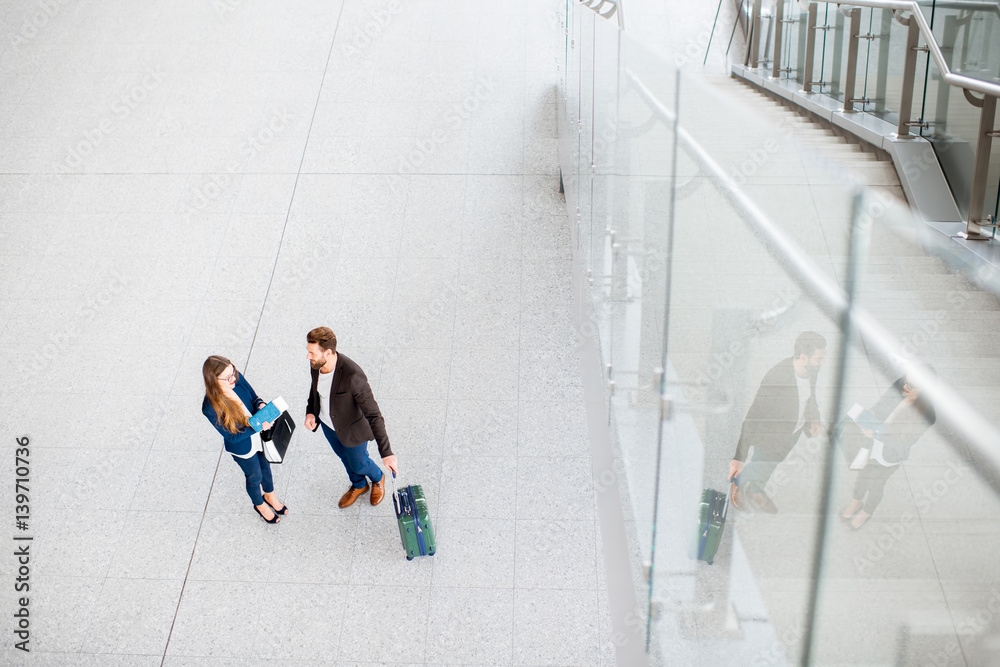 Business couple standing together with baggage at the airport. Top, wide angle view with copy space