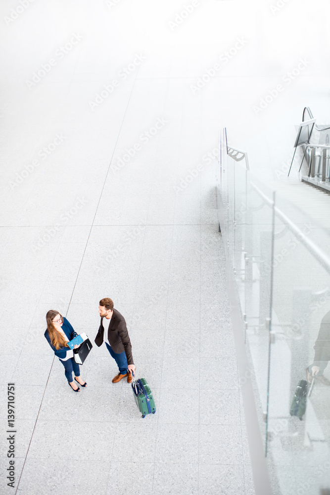 Business couple standing together with baggage at the airport. Top, wide angle view with copy space