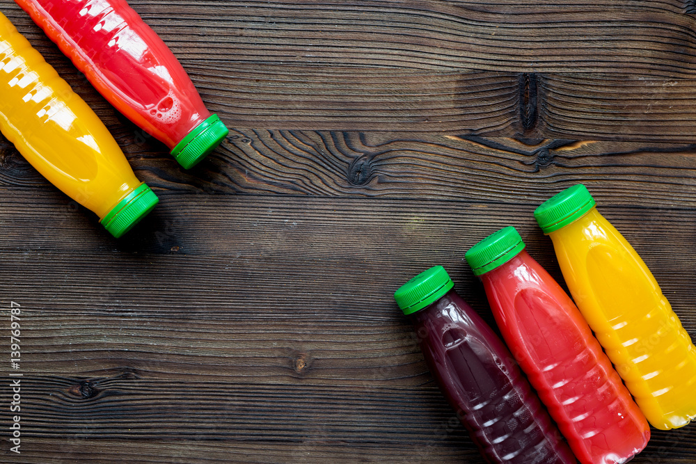 plastic bottles with fruit drinks on wooden background top view mockup