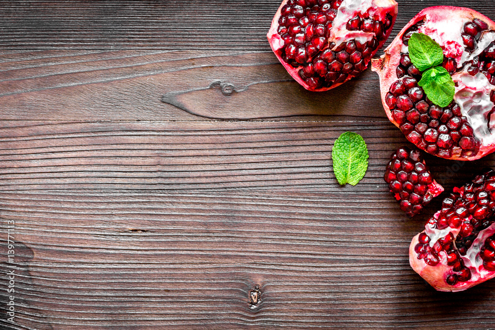 sliced pomegranate on wooden background top view