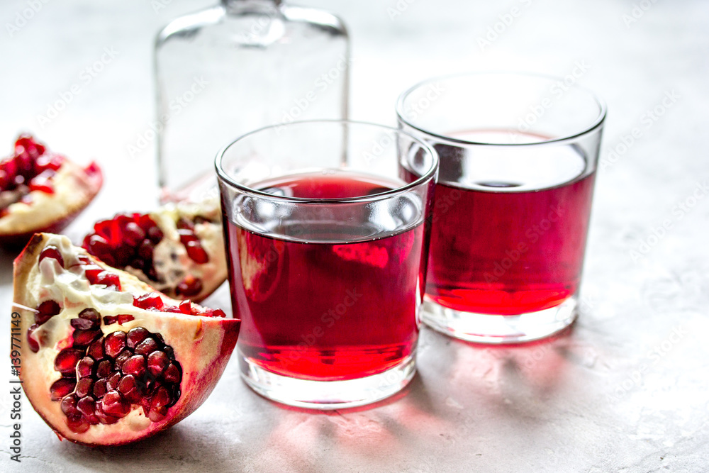 bottle of pomegranate juice with slices on stone table