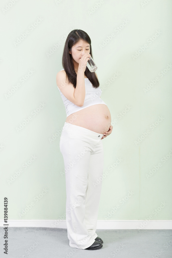 young pretty pregnant woman on background