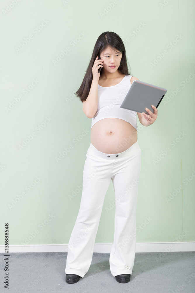 young pretty pregnant woman with tablet