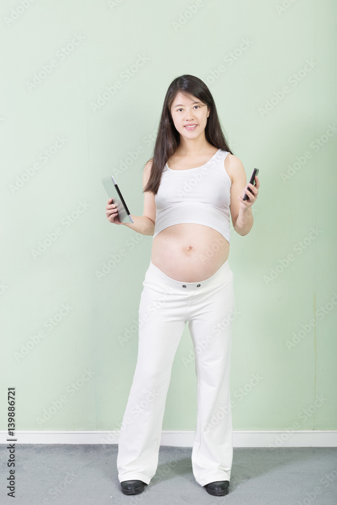 young pretty pregnant woman with tablet