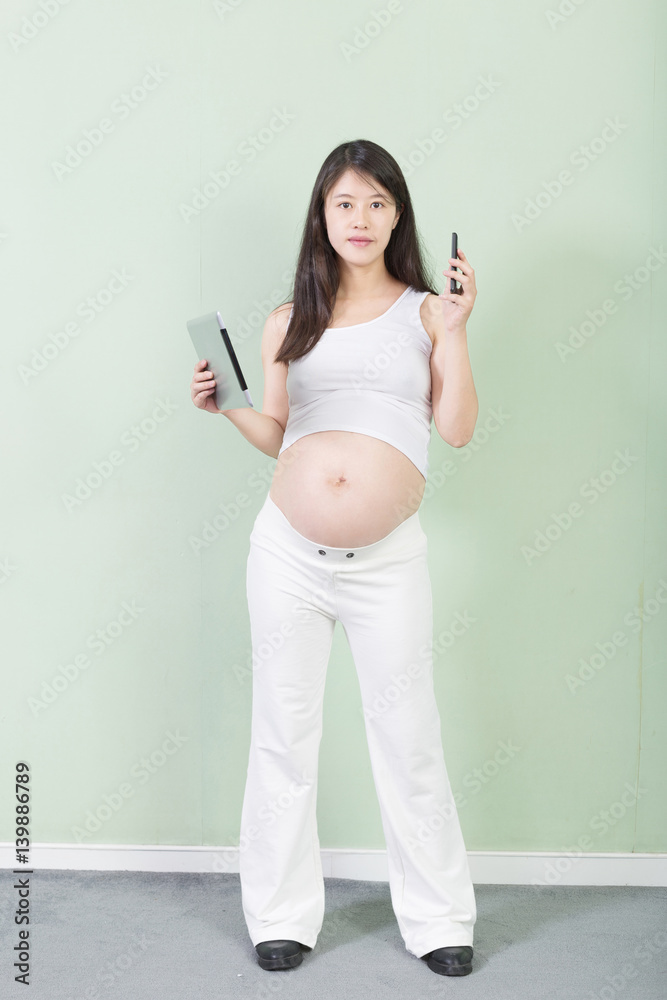 young pretty pregnant woman with tablet