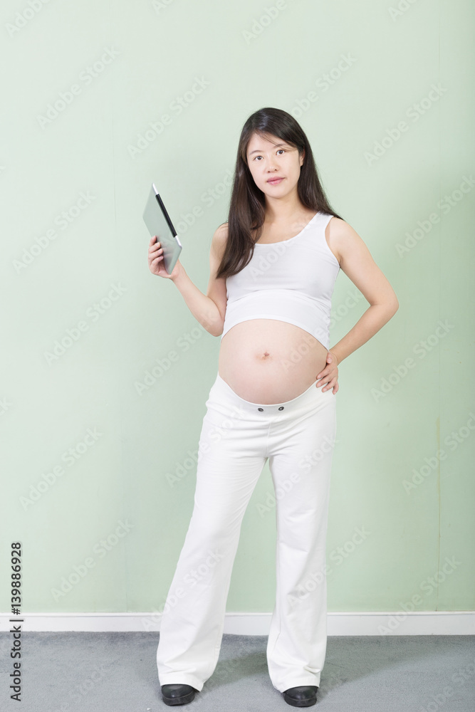 young pretty pregnant woman with tablet