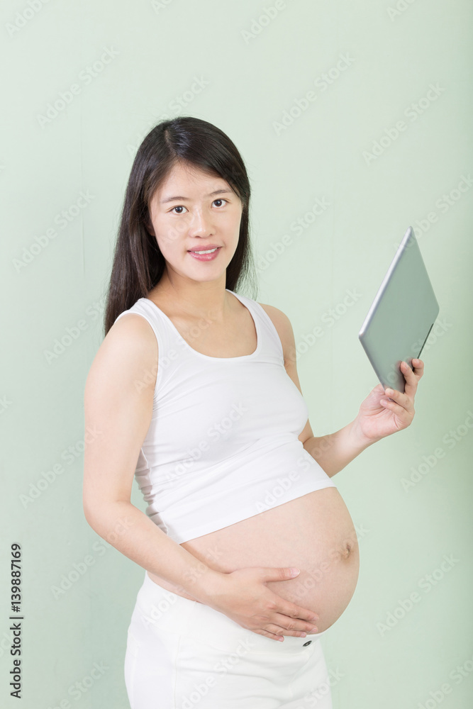 young pretty pregnant woman with tablet