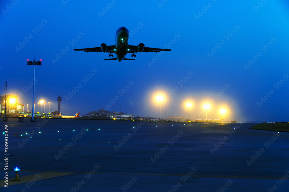 passenger plane fly up over take-off runway from airport at sunset