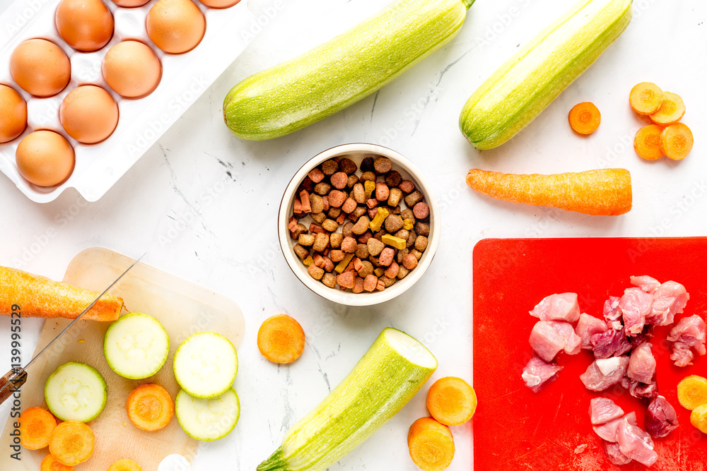 Dogfood set with vegetables, eggs and meat on table background top view