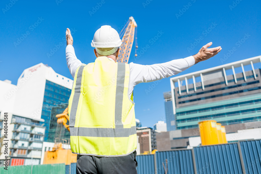 Senior foreman in glasses doing his job at building area on sunny day