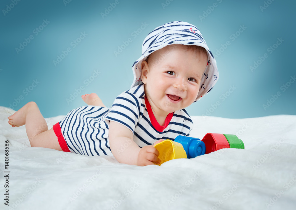 Nine month old baby lying in the bed on white blanket