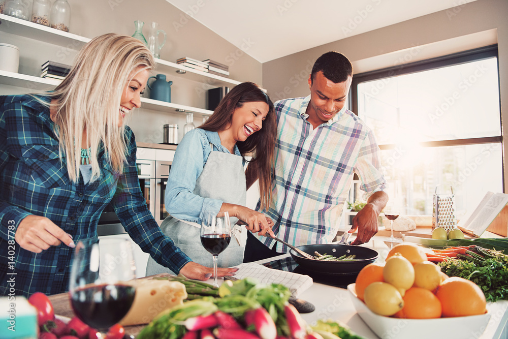 Three friends at kitchen cooking