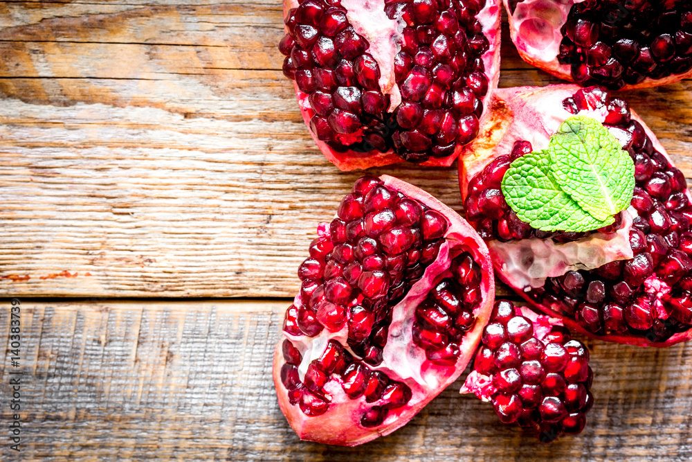 sliced pomegranate on wooden background top view