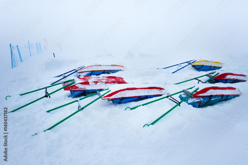 Snow-covered rescue sleds for injured skiers