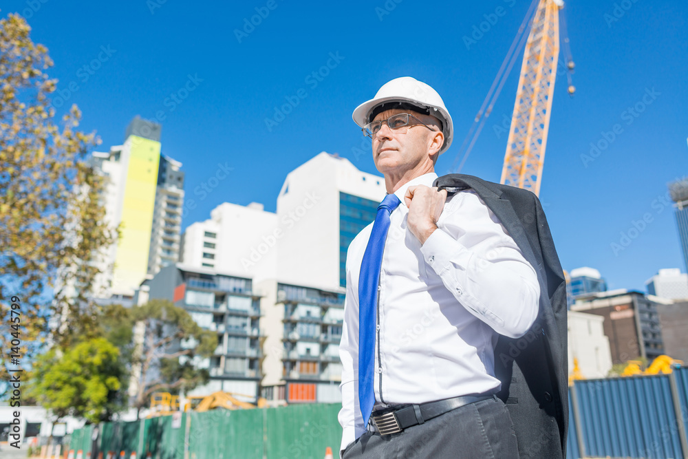 阳光明媚的夏日，穿着西装的高级优雅建筑工人在施工现场