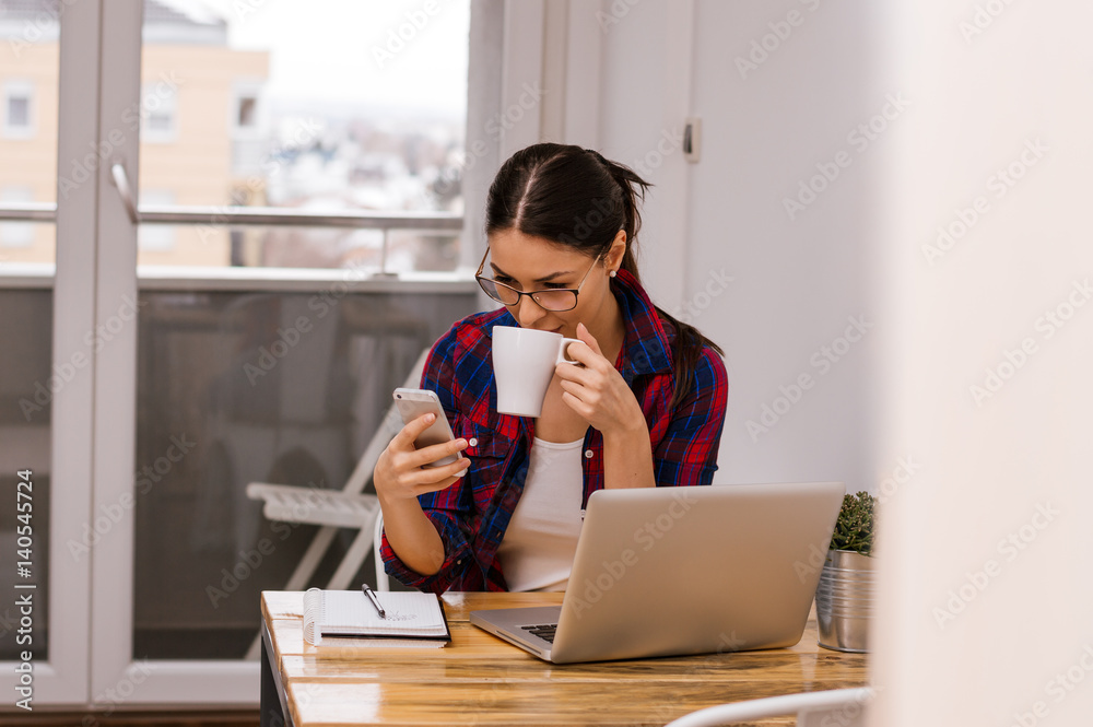 女性设计师在家庭办公室喝早茶或咖啡