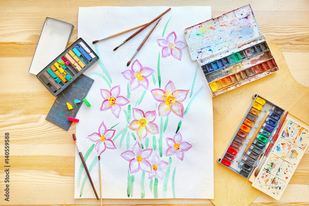 Set of watercolors, crayons, brushes and beautiful picture on wooden table