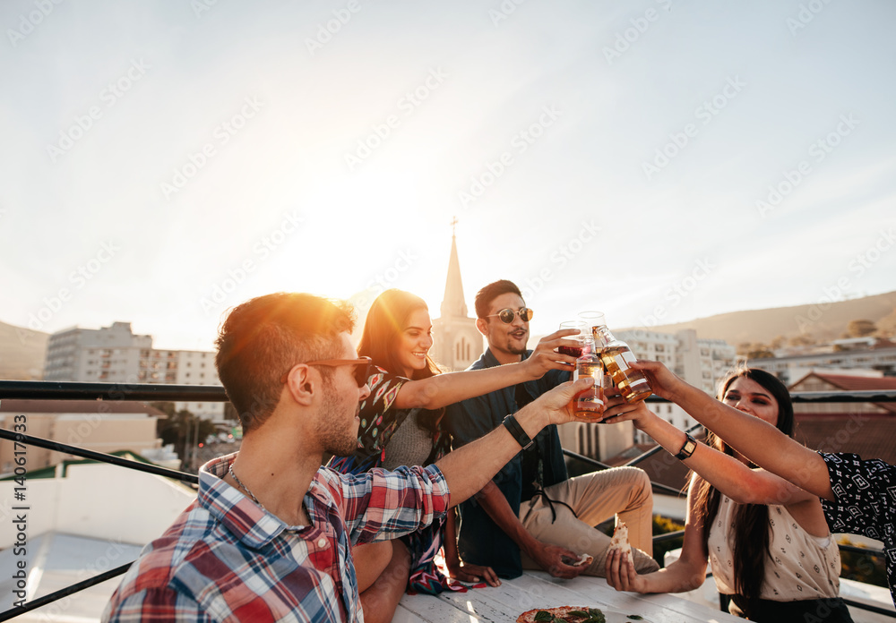 Friends hanging out with drinks on rooftop party