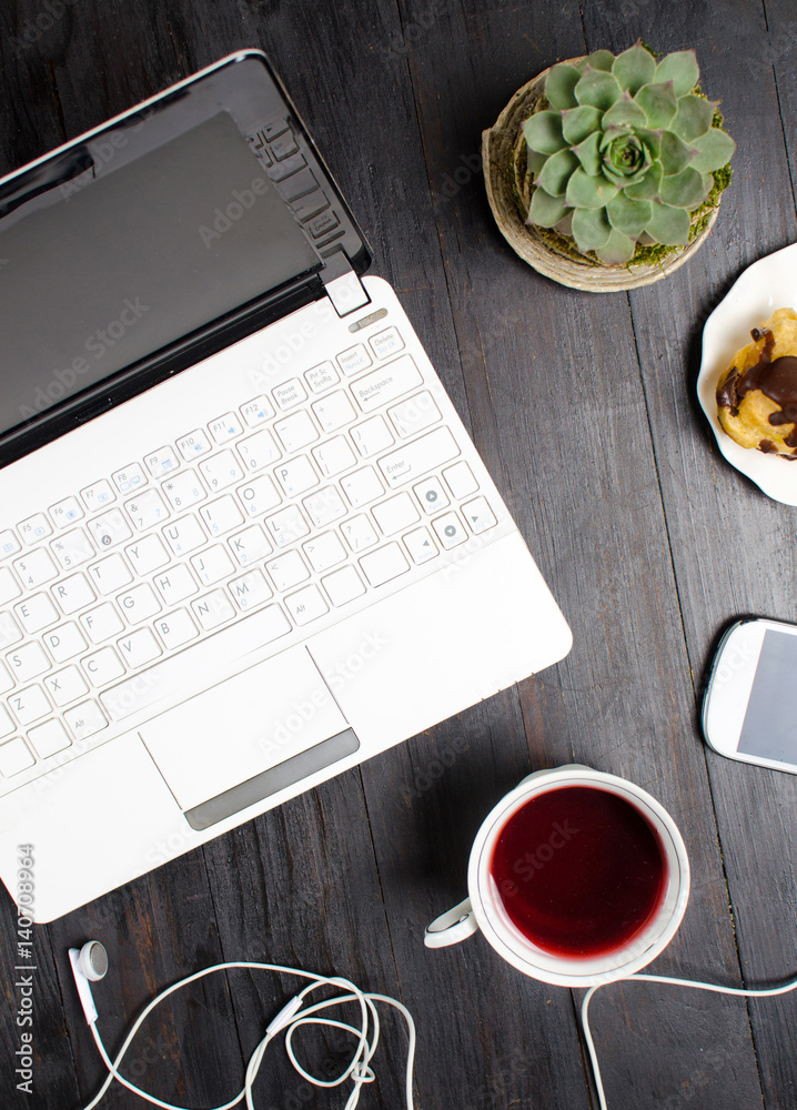 Tea and dessert on a table with a laptop