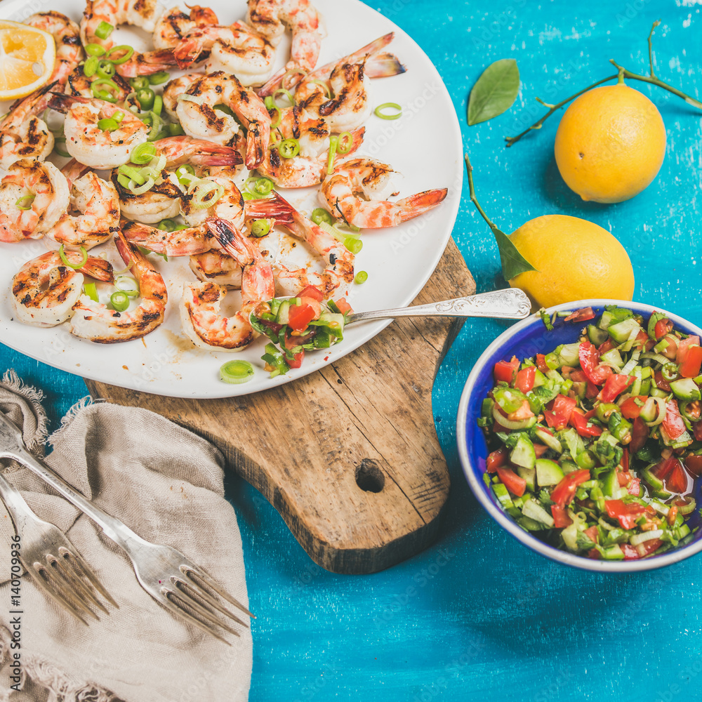 Seafood dinner. Grilled tiger prawns in white plate with lemon, leek, chili pepper and mint salsa sa